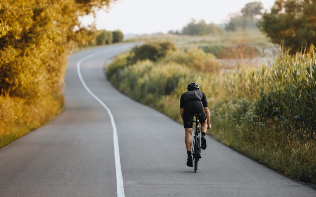 Cyclist riding at paved road in black helmet and sportswear